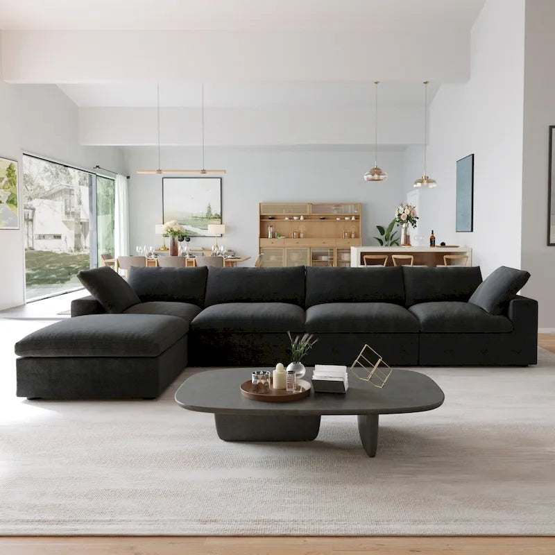 Canapé d’angle noir généreusement rembourré de duvet avec pouf