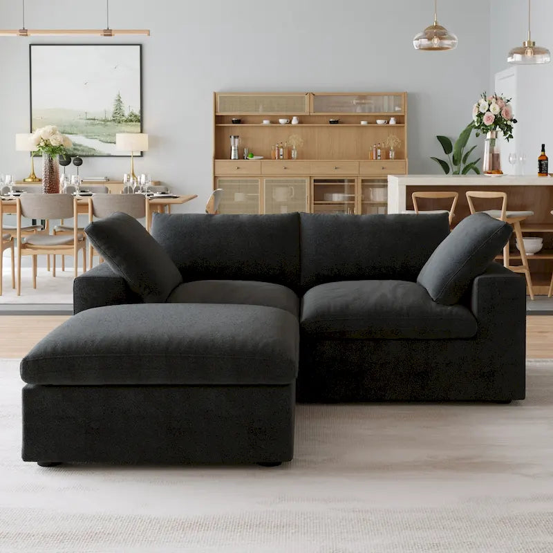 Canapé d’angle noir généreusement rembourré de duvet avec pouf