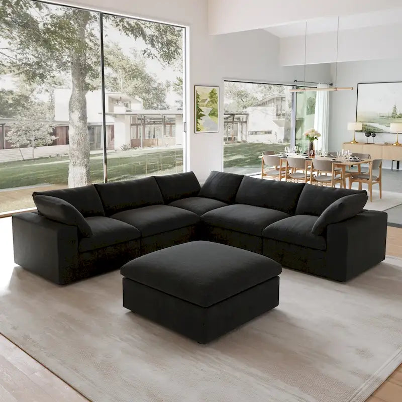 Canapé d’angle noir généreusement rembourré de duvet avec pouf