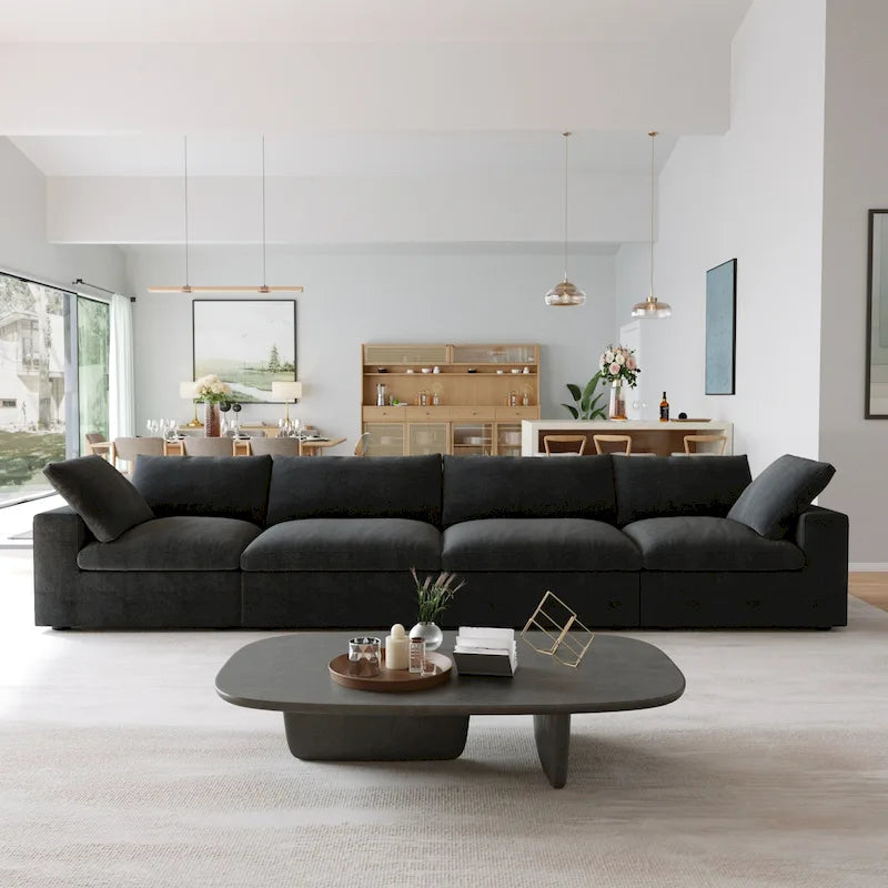 Canapé d’angle noir généreusement rembourré de duvet avec pouf