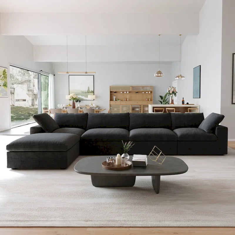 Canapé d’angle noir généreusement rembourré de duvet avec pouf